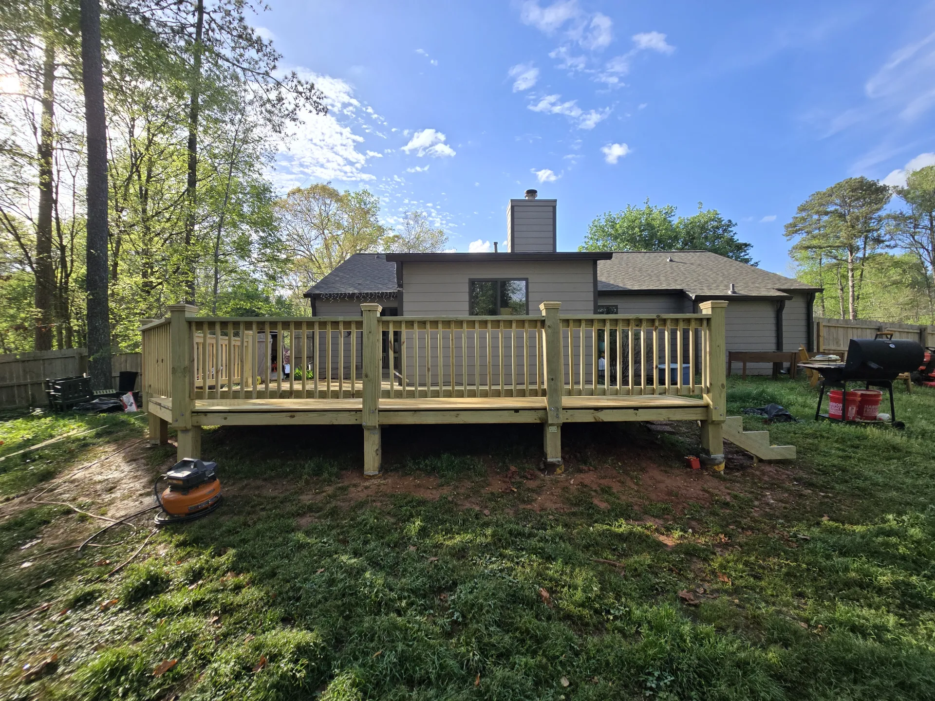 Full backyard view of completed deck with wood railings