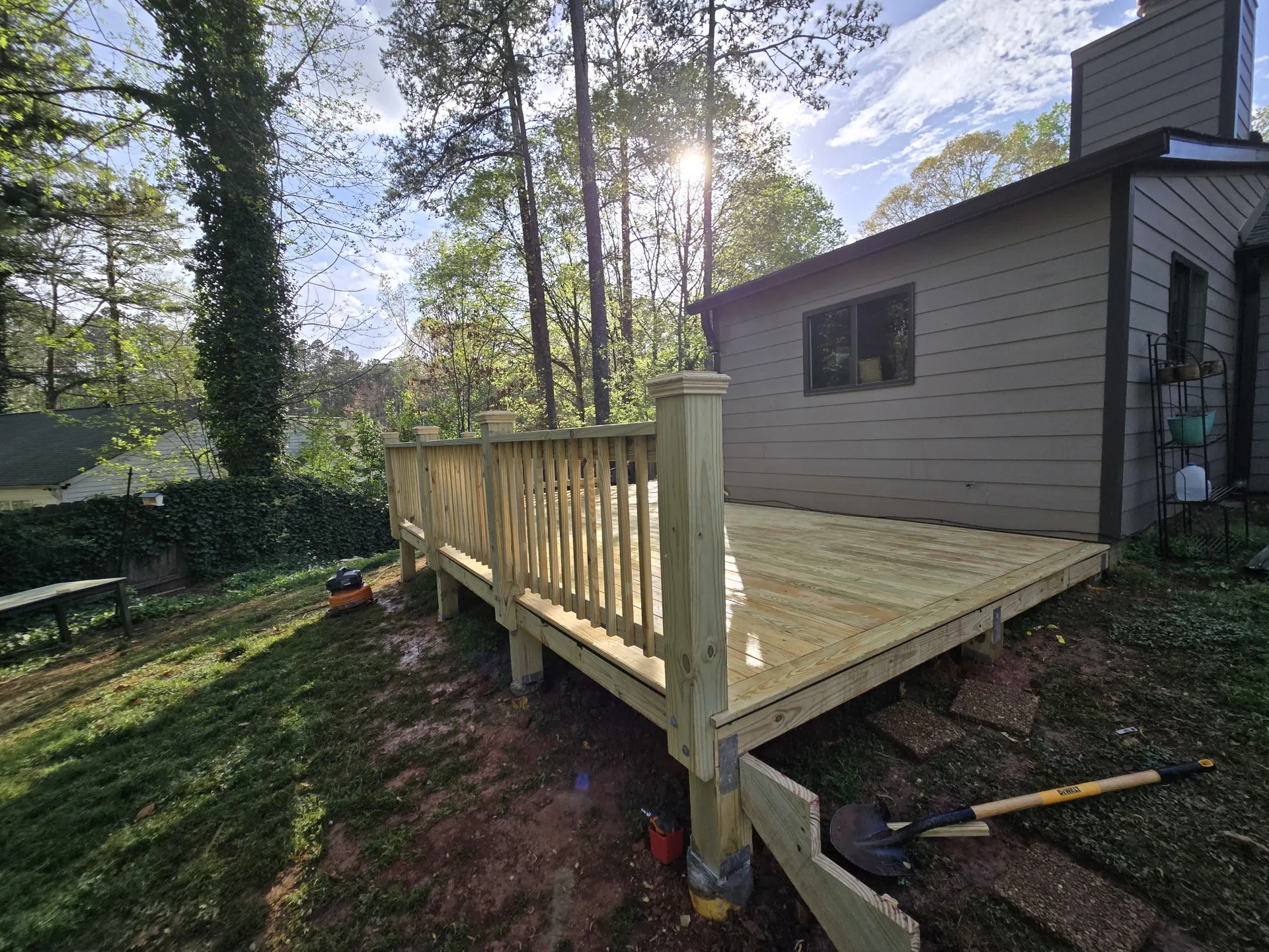 Deck corner with sun through trees