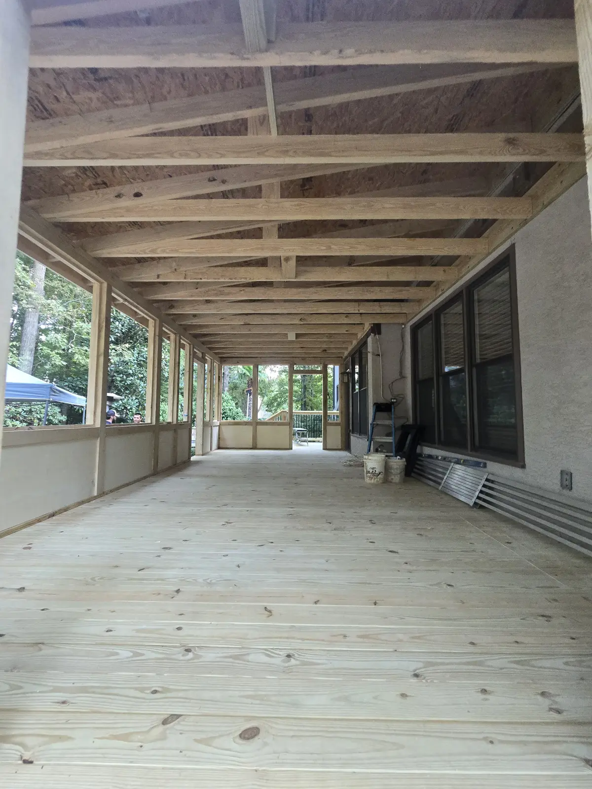Interior of screened porch showing ceiling joists and deck floor